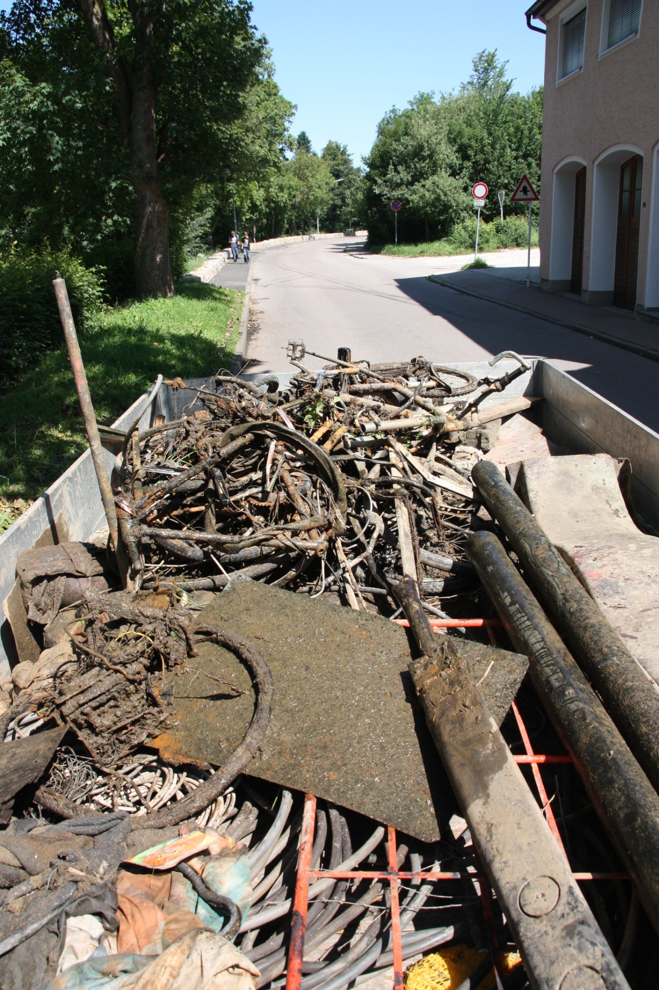 Gewässerreinigung Ein Haufen Metallrecyclingmaterial auf einem Anhänger in städtischer Umgebung.